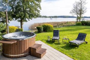 a hot tub in a yard with two chairs at Family Lake House in Mikołajki