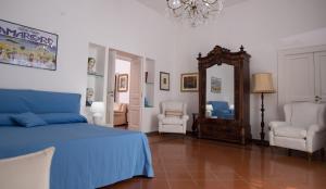 a bedroom with a bed and a mirror and chairs at Casa Beatrice Amalfi Coast in Vietri sul Mare +20 photos