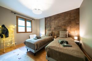 een slaapkamer met 2 bedden en een stenen muur bij Chalet Le cocon plein sud in Saint-Chaffrey +17 foto's