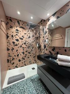 ein Badezimmer mit einem schwarzen Waschbecken und einer mit Schmetterlingen bedeckten Wand in der Unterkunft Las Suites de Platería in Murcia