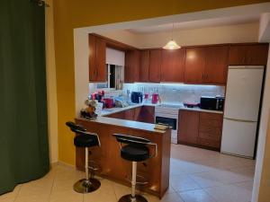 een keuken met houten kasten en een witte koelkast bij Aegean Helios Houses in Gennadi