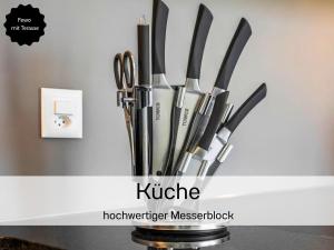 a group of knives in a holder on a counter at Ferienhausträume - ebenerdiges Bodensee Apartment mit Garten und großer Terrasse mit Grill in Kreuzlingen +37 photos