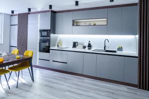 eine Küche mit blauen Schränken sowie einem Tisch und Stühlen in der Unterkunft Cozy and Stylish Apartment 2 in Stara Sagora + 25 Fotos