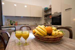 a basket of fruit and two glasses of orange juice on a table at Casa Beatrice Amalfi Coast in Vietri sul Mare