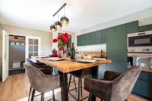 een keuken met een lange houten tafel en stoelen bij Chalet Le cocon plein sud in Saint-Chaffrey