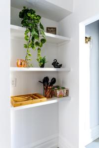 una stanza con mensole bianche con piante sopra di Short North Convention King Bed Free Parking! a Columbus