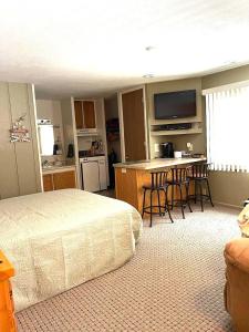 a bedroom with a bed and a kitchen with a table at Schuss #145 Walk to ski hill in Mancelona