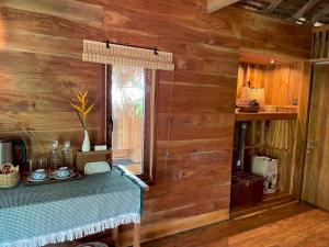 ein Zimmer mit Holzwänden und einem Tisch mit Fenster in der Unterkunft The Tropical Koh Mook in Ko Mook