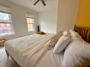 una camera da letto con un gatto steso sopra di Jungle House Columbus Sleep 12 Downtown Ohio Free Parking - Near Convention Center & Nationwide Arena - 4BR Short North Luxury Home - Over 5,800 Five Star Stays a Columbus