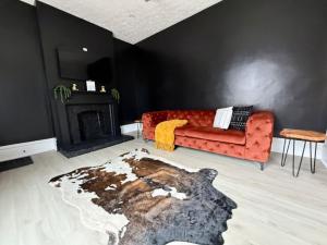 un soggiorno con un divano rosso e un camino di Jungle House Columbus Sleep 12 Downtown Ohio Free Parking - Near Convention Center & Nationwide Arena - 4BR Short North Luxury Home - Over 5,800 Five Star Stays a Columbus Altre 34 foto