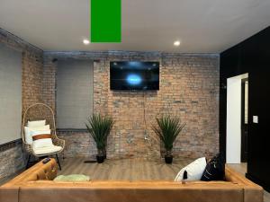 un soggiorno con una TV su un muro di mattoni di Jungle House Luxury Stays - Columbus Downtown Short North a Columbus