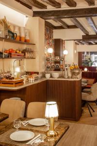cocina con mesa, sillas y barra en Hotel Des Deux Continents, en París