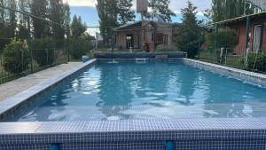 a swimming pool with blue water in a yard at cabañas elita in San Rafael