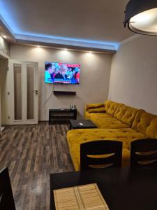 a living room with a couch and a flat screen tv at Апартамент Top Central in Yambol