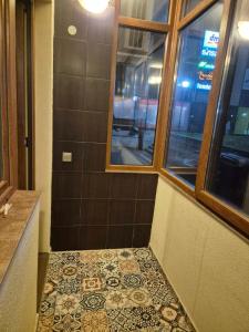 a bathroom with a tile floor and a window at Апартамент Top Central in Yambol