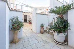 a courtyard with potted plants and stairs in a building at Giardino dellorologio - Salento Reservation in Racale