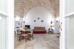 a living room with a table and chairs and a couch at Giardino dellorologio - Salento Reservation in Racale