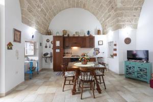 a kitchen and dining room with a table and chairs at Giardino dellorologio - Salento Reservation in Racale