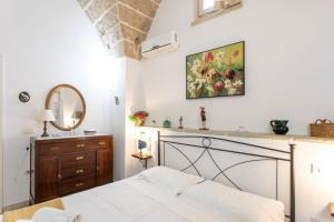 a bedroom with a bed and a dresser and a mirror at Giardino dellorologio - Salento Reservation in Racale +24 photos
