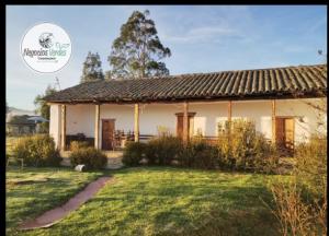 a house with a grass yard in front of it at Posada Turistica Altamisal in Firavitoba