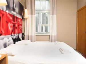 a bedroom with a bed and a red wall at Ibis Riga Centre in Rīga