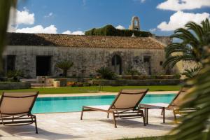 a group of chairs sitting next to a swimming pool at Masseria Eirene in Lecce