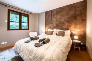 een slaapkamer met een groot bed met kussens erop bij Chalet Le cocon plein sud in Saint-Chaffrey