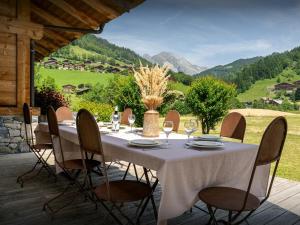 einen Tisch mit Weingläsern und Stühlen auf einer Terrasse in der Unterkunft Chalet Ibusta - OVO Network in Le Grand-Bornand
