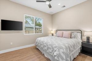 een slaapkamer met een bed en een flatscreen-tv bij Modern NB Getaway with Pool in New Braunfels