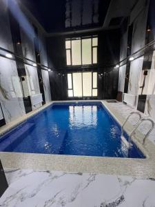 Zamin Dacha的建筑物内有一个大型蓝色游泳池。