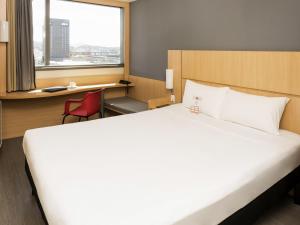 a bedroom with a large white bed and a window at ibis Rio Porto Atlantico in Rio de Janeiro