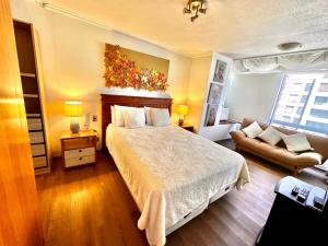a bedroom with a large bed and a couch at sanhatan in Santiago