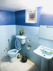 a blue bathroom with a toilet and a sink at Mihira Guest House in Ahangama +32 photos