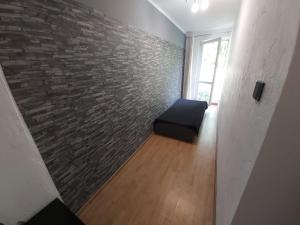 a room with a brick wall and a chair at 2051 Zwycięstwa 23 - Tanie Pokoje - samodzielne zameldowanie - self check in in Poznań