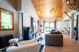 een woonkamer met een bank en een stoel bij Chalet Le cocon plein sud in Saint-Chaffrey