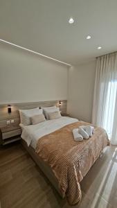 a bedroom with a large bed with two pillows on it at K & V apartments in Amfiklia