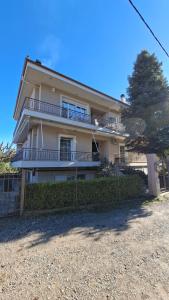 a large house with a fence in front of it at K & V apartments in Amfiklia
