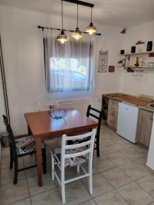 a kitchen with a wooden table and chairs in a room at Domus Foresta Apartmani in Brdo