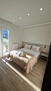 a bedroom with a large bed and a large window at K & V apartments in Amfiklia