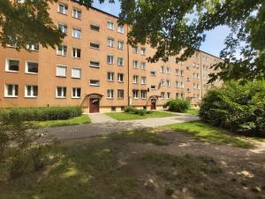a large brick building with a pathway in front of it at 2051 Zwycięstwa 23 - Tanie Pokoje - samodzielne zameldowanie - self check in in Poznań