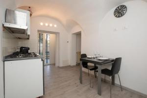 eine Küche mit einem Tisch mit Stühlen und einem Herd in der Unterkunft Dalia's Home Garden and Private Parking in Calice Ligure