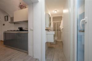 eine weiße Küche mit einer Spüle und einer Theke in der Unterkunft Dalia's Home Garden and Private Parking in Calice Ligure