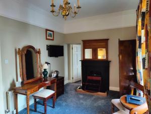a living room with a fireplace and a mirror at Townsend House Guest House in Birr