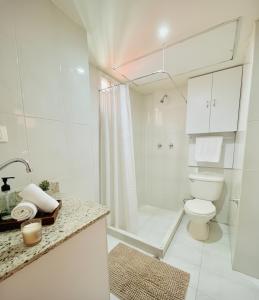 a white bathroom with a toilet and a shower at Exclusivo Apartamento en Lecherías 1 min caminando hasta la playa in El Morto de Barcelona
