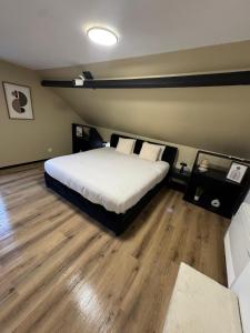 a bedroom with a bed and a wooden floor at La suite Nova - Jacuzzi in Valenciennes