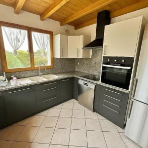 eine Küche mit grünen Schränken, einem Waschbecken und einem Fenster in der Unterkunft CAL QuEROL UR casa amb xemeneia i billar in Ur