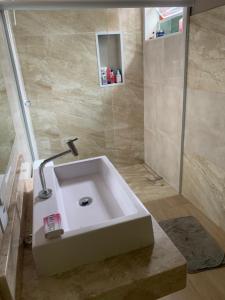 un bagno con un lavandino bianco e una doccia di Recanto Pedrita a Pedreira