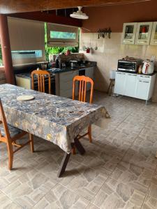 una cucina con tavolo, sedie e bancone di Recanto Pedrita a Pedreira
