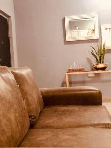 a brown couch sitting in a living room at Secret-Meadow Accommodation in Maun