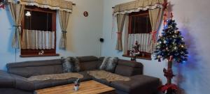 ein Wohnzimmer mit einem Weihnachtsbaum und einer Couch in der Unterkunft Wellness Chata Horbek in Vyšné Ružbachy